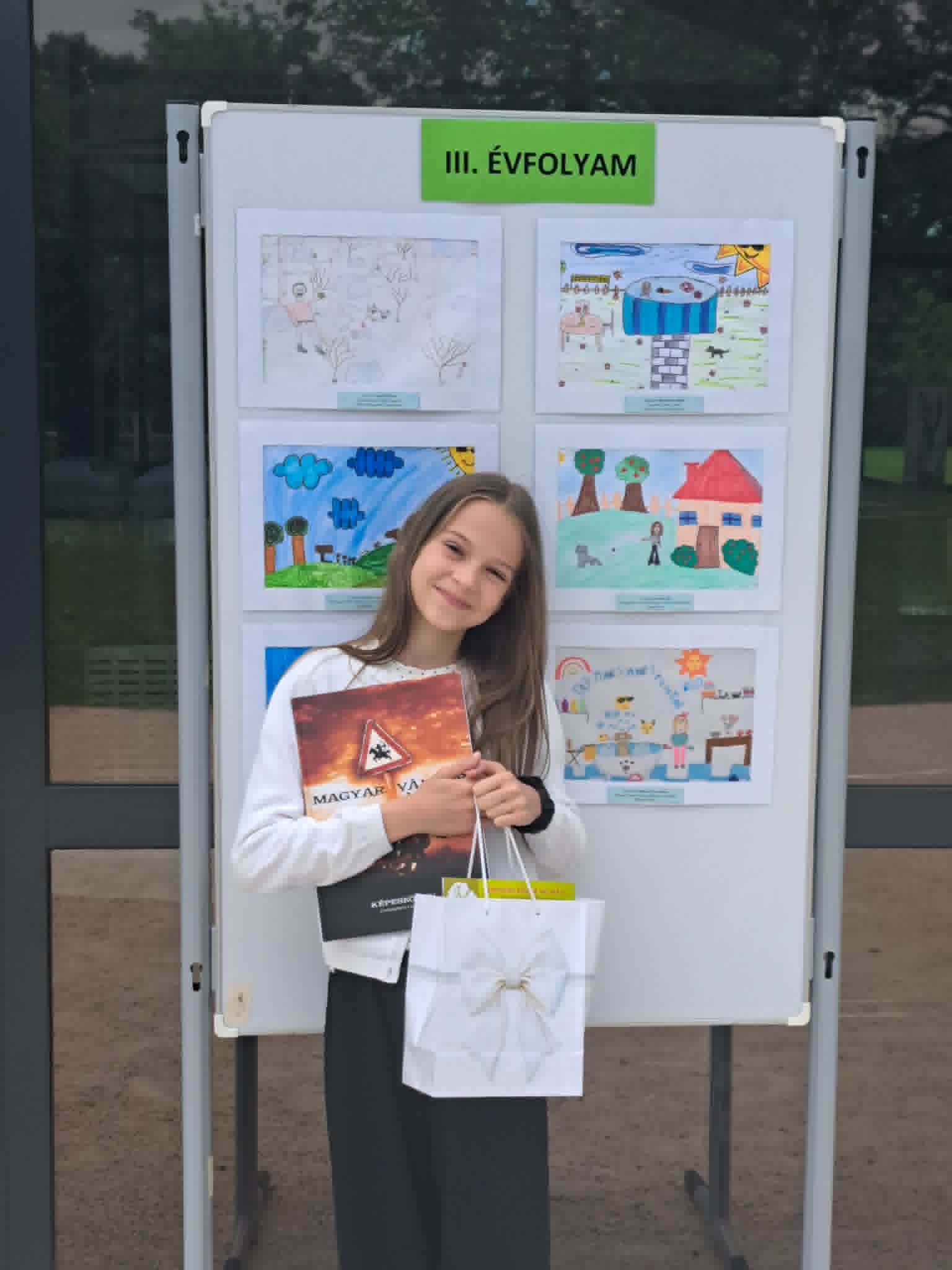 Lilla a díjazott munkák előtt